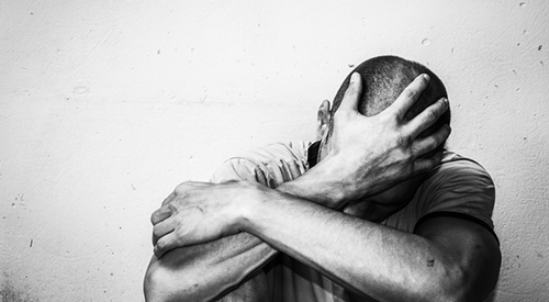 depressed on the street feeling anxious and lonely, social documentary concept black and white;  Credit: iStock/Srdjanns74
